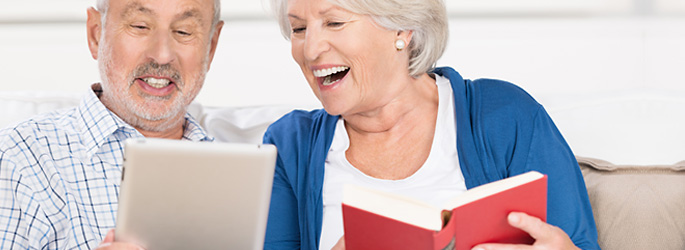 Senioren nutzen ein Tablet zum Lesen