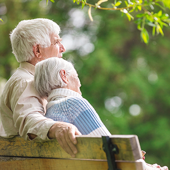 Älteres Ehepaar sitzt auf einer Parkbank