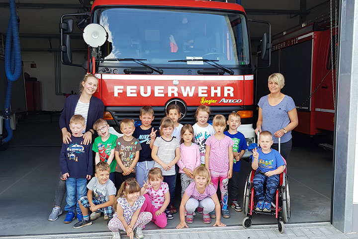 Eine Kindergruppe steht vor einer Feuerwehr