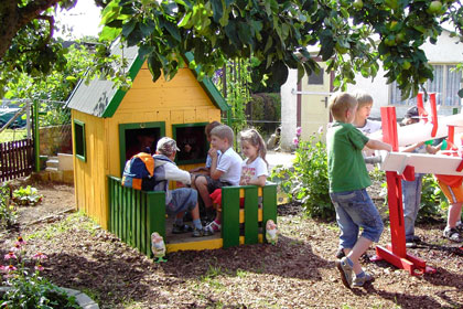 Kinder in einem Spielhaus des Naturerlebnisgartens für Kinder