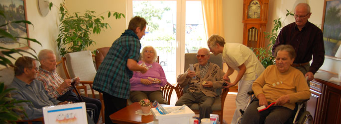 Eine Gruppe von Senioren im Beisein von Pflegepersonal
