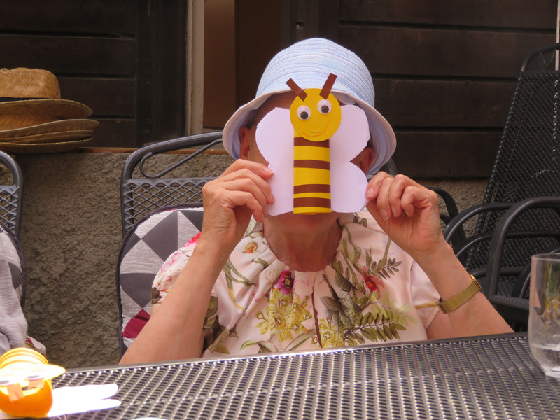 eine ältere Dame hält eine gebastelte Biene